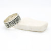 Celtic knot solid band ring on a white stone on a white background