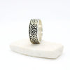 Celtic knot solid band ring on a white stone on a white background