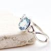 Silver ring with a blue gemstone on a light background