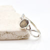 Silver ring with a labradorite gemstone on a white background