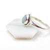 Silver ring with an aquamarine gemstone on a white stone surface