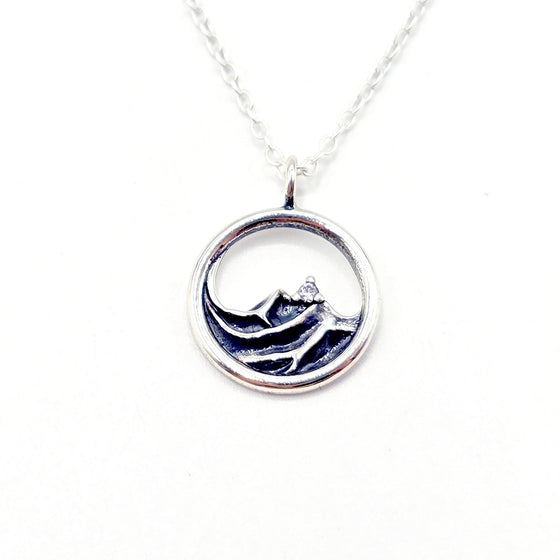 Silver necklace with a circular pendant that are waves