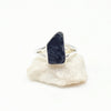 Ring with a raw irregular black tourmaline stone on a white background