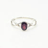 Silver ring with a red garnet gemstone on a white background