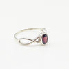 Silver ring with a red gemstone on a white background