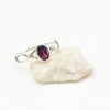 Silver ring with a red garnet gemstone on a white background