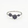 Silver ring with three daisy flower design on a white background