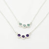 Two silver necklaces, with amethyst and aquamarine gemstones on a white background