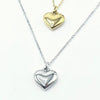 Two heart-shaped pendant necklaces on delicate chains, one in polished gold and one in polished silver,Part of our engravable collection. Made in stainless steel