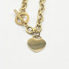 A gold-tone chain bracelet with a toggle clasp and a flat heart-shaped charm, shown on a plain white background. heart charm is engravable