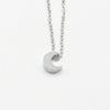 A minimalist high-polish stainless steel necklace featuring a dainty, solid crescent moon pendant on a delicate cable chain, Availble in Silver and Gold. Part of the Engravable Collection