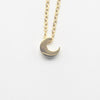 A minimalist high-polish stainless steel necklace featuring a dainty, solid crescent moon pendant on a delicate cable chain, Availble in Silver and Gold. Part of the Engravable Collection