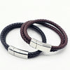 Two braided leather bracelets, one black and one dark brown, each featuring a polished stainless steel  silver rectangular clasp.  Part of the engravable collection