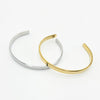 Two slim open cuff bangles, one polished silver-tone and one polished gold-tone, Made from Stainless Steel. Part of our engravable Range