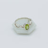Silver ring with a green gemstone on a white background
