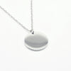 A minimalist high-polish stainless steel necklace featuring a blank 15mm round disk pendant